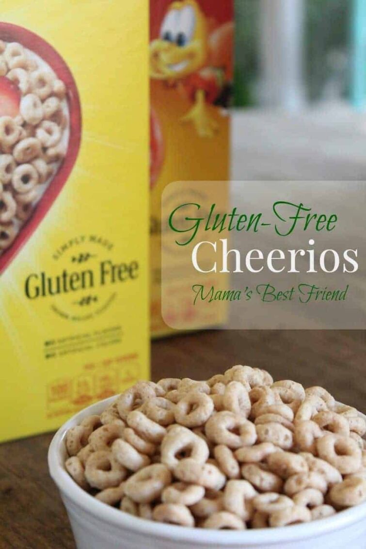 Image shows a large box of Cheerios behind a close up of a bowl of Cheerios with text overlay that reads "Gluten-Free Cheerios Mama's Best Friend"
