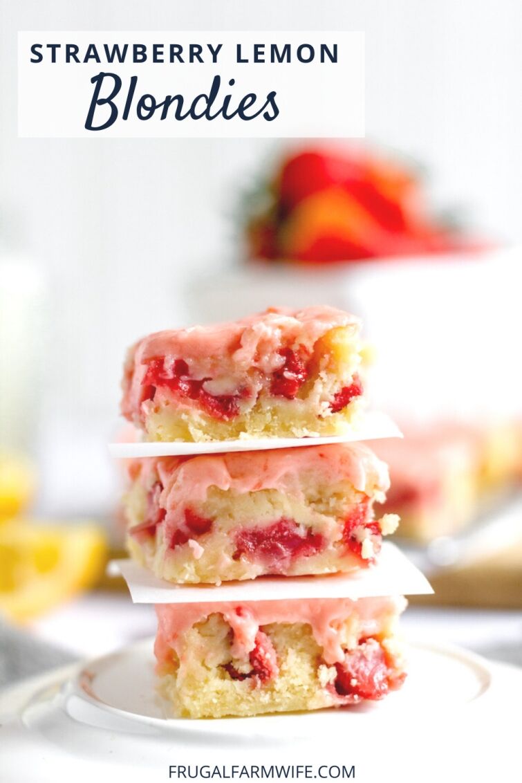 Photo shows a stack of strawberry lemon blondies on a plate, separated by a piece of white paper. Blurred in the background are red strawberries and yellow lemons. Text overlay reads "Strawberry Lemon Blondies"
