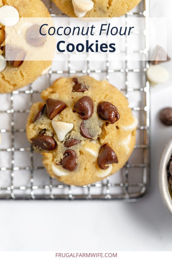 Image, taken from above, shows a close up of a chocolate chip cookie with both milk and white chocolate chips on a cooling rack. Text box above reads "Coconut Flour Cookies"