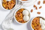 bowls of pumpkin dump cake served with extra pecans and ice cream